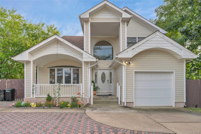 View of front facade with driveway, a garage, and a porch