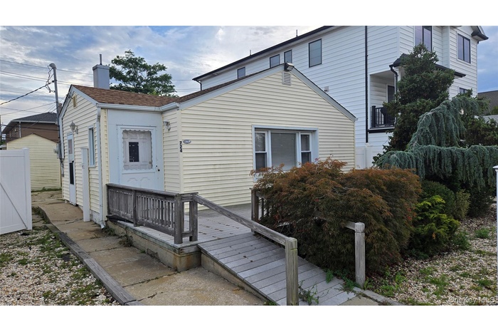 View of front of house with a chimney and a deck
