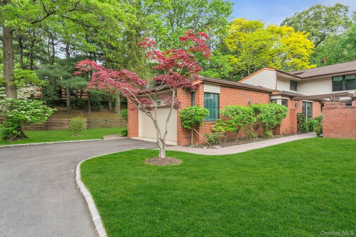 View of front of home with asphalt driveway, a front yard, and brick siding