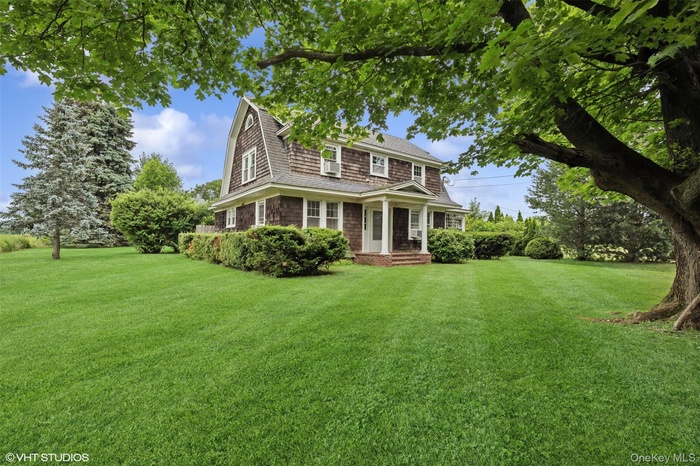 Shingle-style home with a front lawn