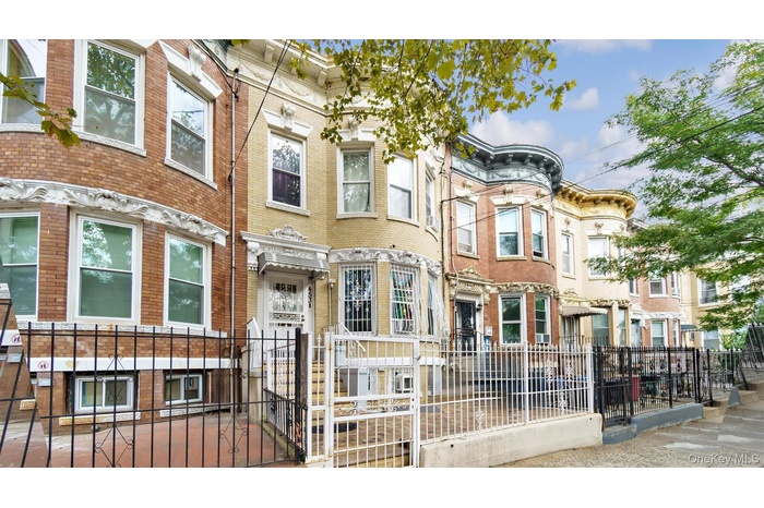 View of front facade featuring a fenced front yard, a residential view, brick siding, and a gate
