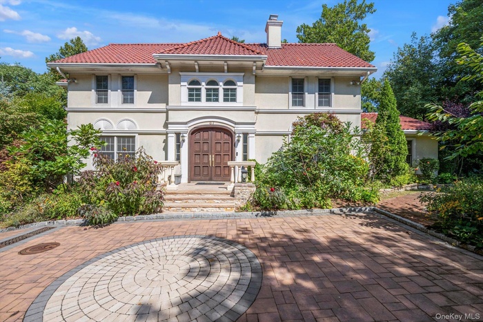 Mediterranean house with stucco siding, a chimney, a patio, and a tile roof