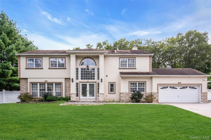 View of front facade featuring stone siding, stucco siding, and french doors