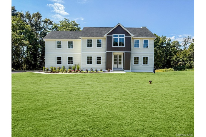 Colonial-style house featuring a front yard