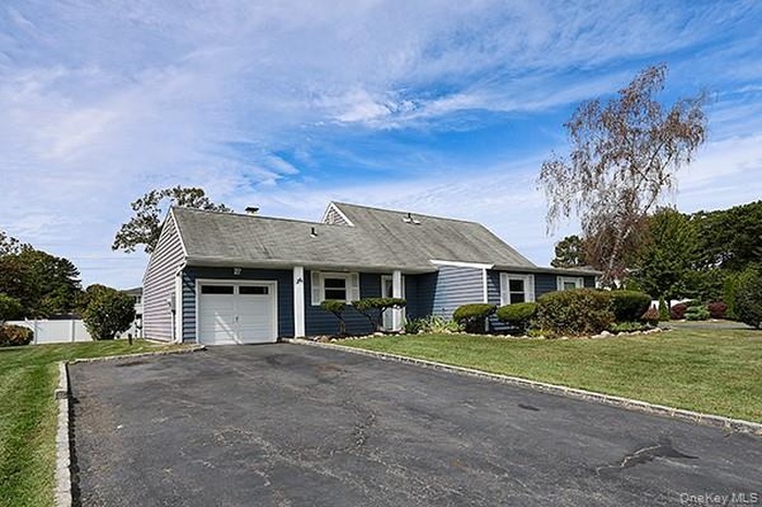 Single story home featuring a front yard, driveway, and an attached garage