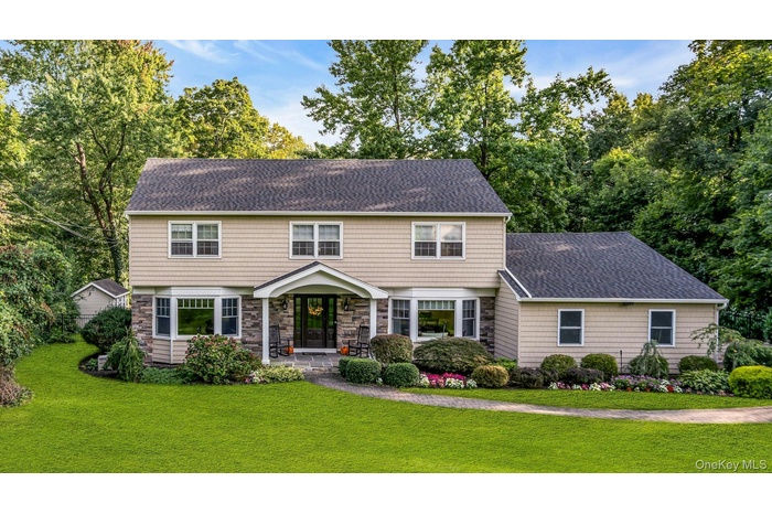 Colonial house with a shingled roof and a front yard