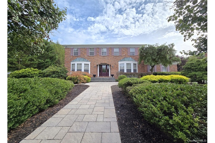 Colonial inspired home featuring brick siding
