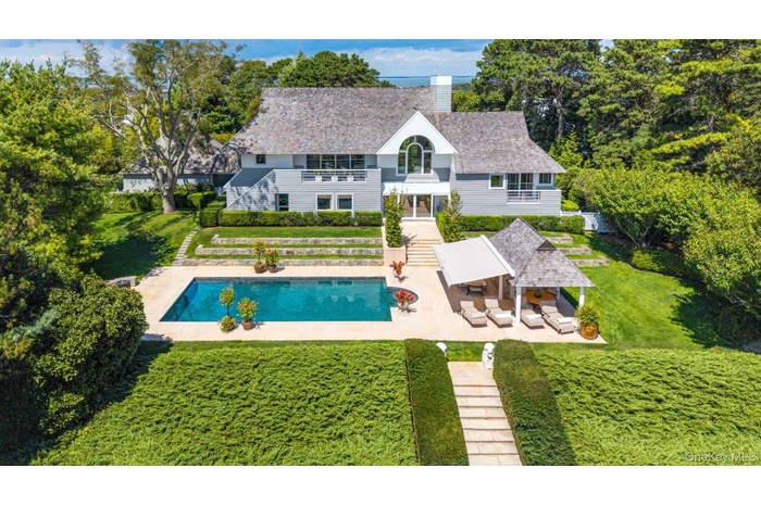 Back of property with a patio area, a balcony, a lawn, a chimney, and an outdoor pool