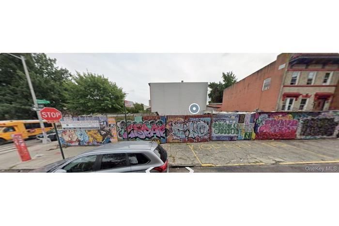 View of asphalt road featuring curbs, street lights, and traffic signs