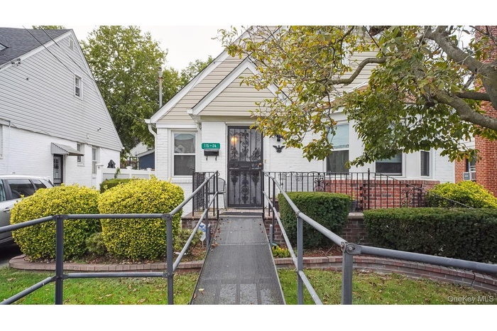 View of front of house featuring brick siding, a fenced front yard, and a gate