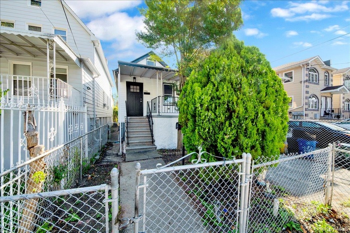 View of front of property featuring a gate, a fenced front yard, stairs, and covered porch