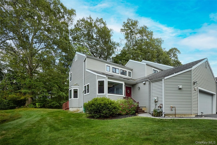 View of front facade featuring a front yard and a garage