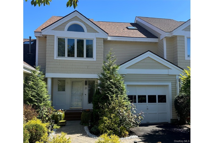 View of front of home featuring a garage and a shingled roof