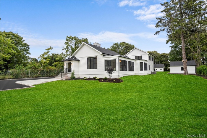 View of front of home with an outdoor structure, a chimney, and board and batten siding