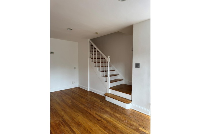 Staircase with hardwood / wood-style flooring and recessed lighting