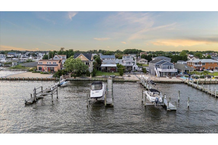 Dock area with boat lift, a residential view, and a water view