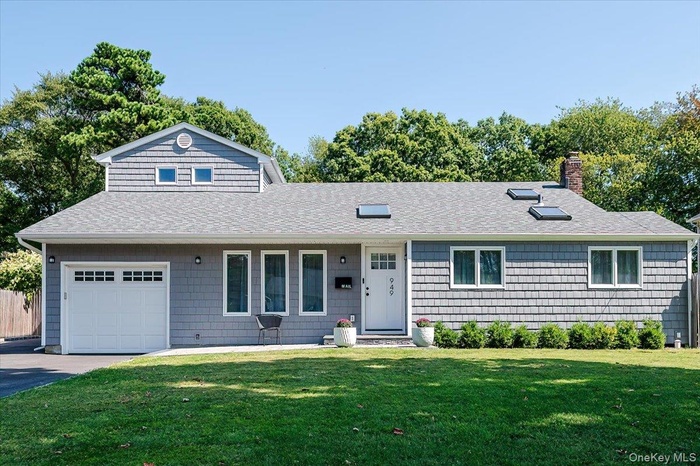 View of front of home featuring roof with shingles and a chimney