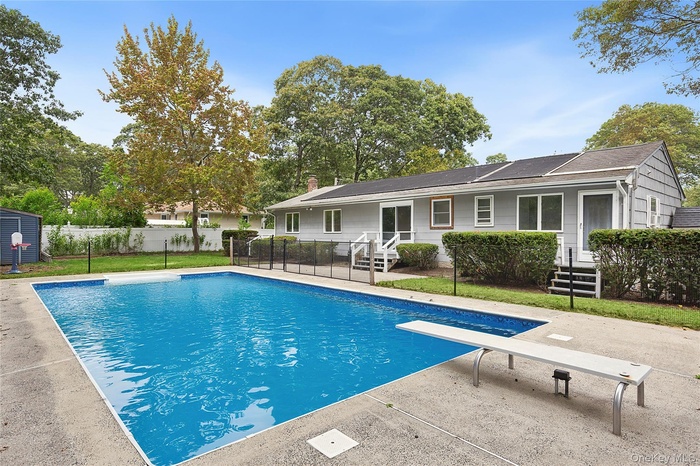 View of pool with a diving board and a patio