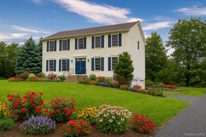 Virtually enhanced - Colonial house with a front yard and an attached garage