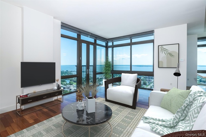 Living area with floor to ceiling windows and wood finished floors