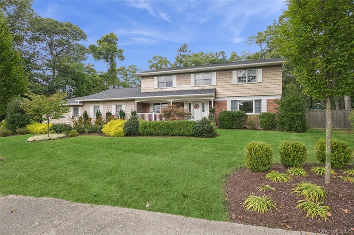 Traditional-style house featuring a porch and brick siding