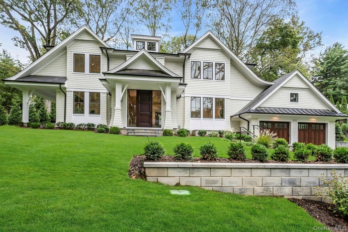 View of front of house with a front lawn, a porch, a standing seam roof, and a metal roof