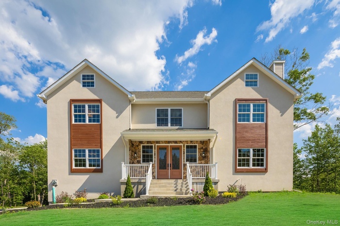 View of front facade with covered porch, stucco siding, a chimney, a front yard, and french doors