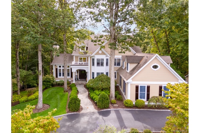 View of front of house with a balcony and a shingled roof
