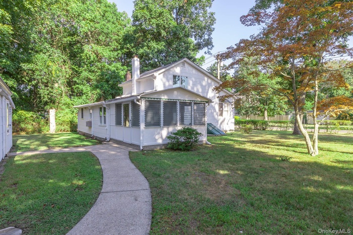 View of front facade with a sunroom and a chimney