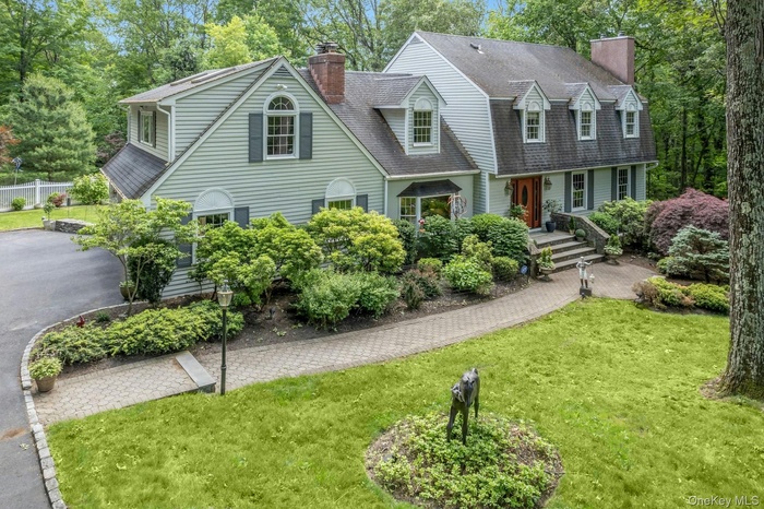 View of front of property with a chimney and a shingled roof