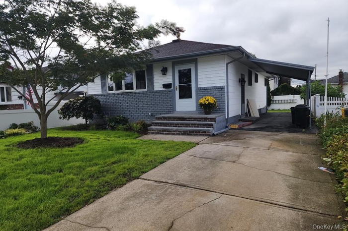 View of front facade featuring brick siding and driveway