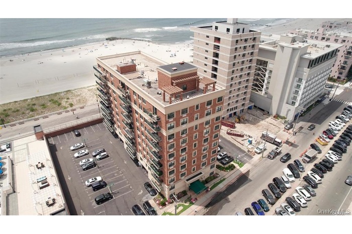 Drone / aerial view with a water view, a beach view, and a city view