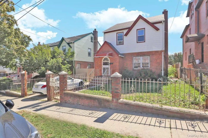 English style home with a fenced front yard and brick siding