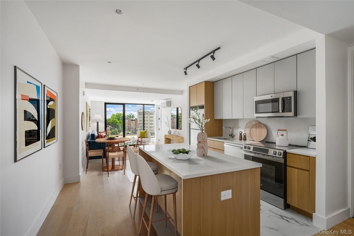 Kitchen featuring appliances with stainless steel finishes, modern cabinets, a breakfast bar area, open floor plan, and a center island