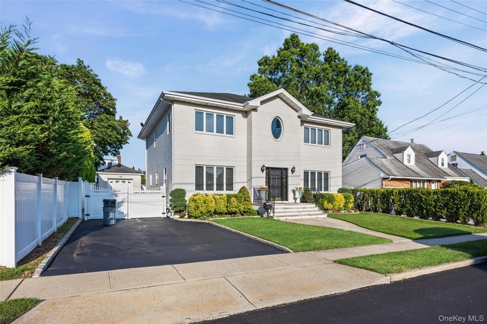 View of front of house featuring a gate, brick siding, and a garage
