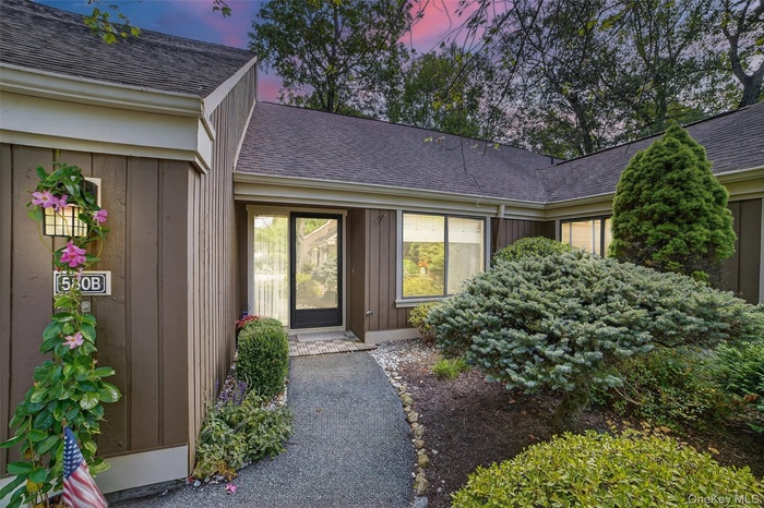 Exterior entry at dusk featuring roof with shingles