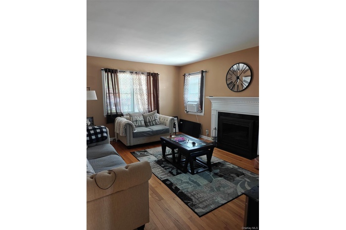 Living area featuring wood finished floors and a fireplace with flush hearth