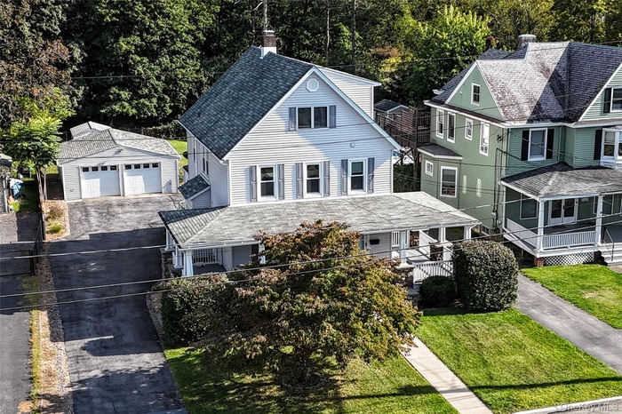 Aerial view showing front yard, driveway and 2-car garage.
