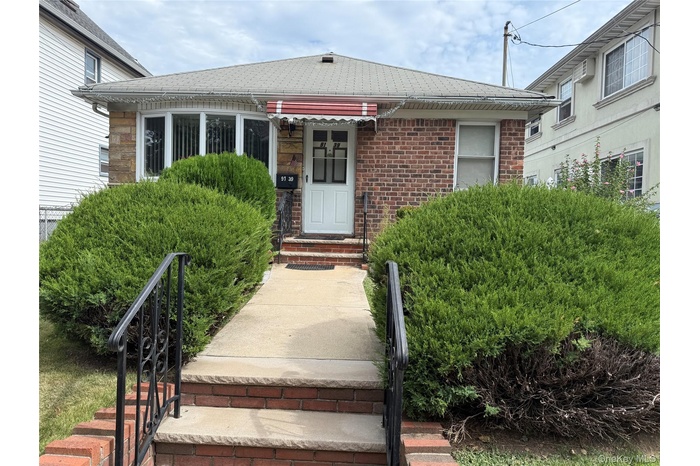 Property entrance featuring brick siding and roof with shingles