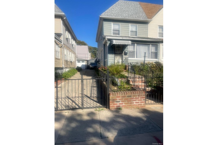 View of front of home featuring a gate, a fenced front yard, and roof with shingles