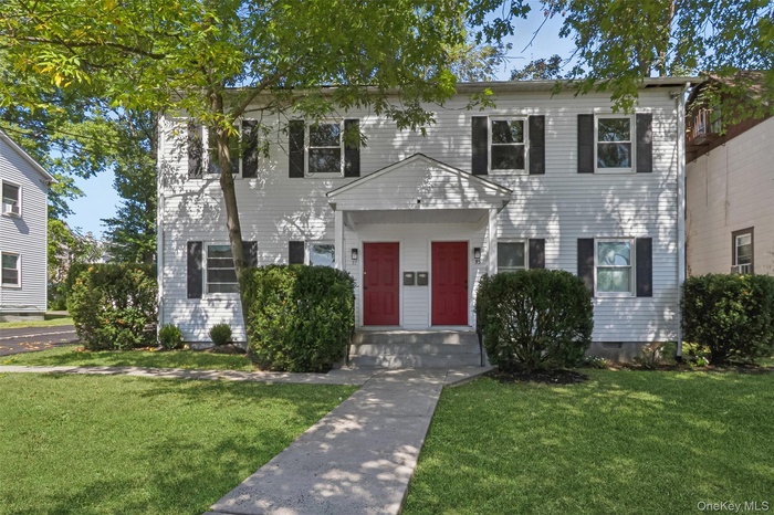 Colonial-style house with a front lawn and crawl space