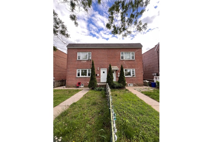 View of front of home with brick siding and a front yard