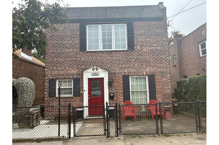 View of front facade with a gate, a fenced front yard, and brick siding