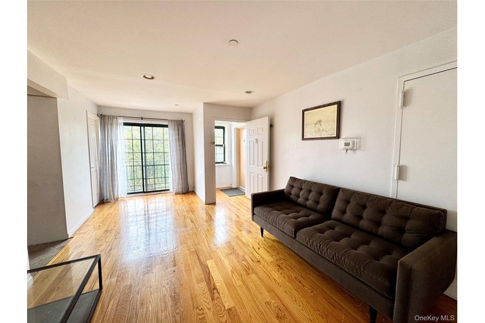 Living area with light wood-style floors and recessed lighting