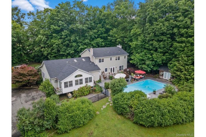 Aerial view of property and surrounding area featuring a pool area