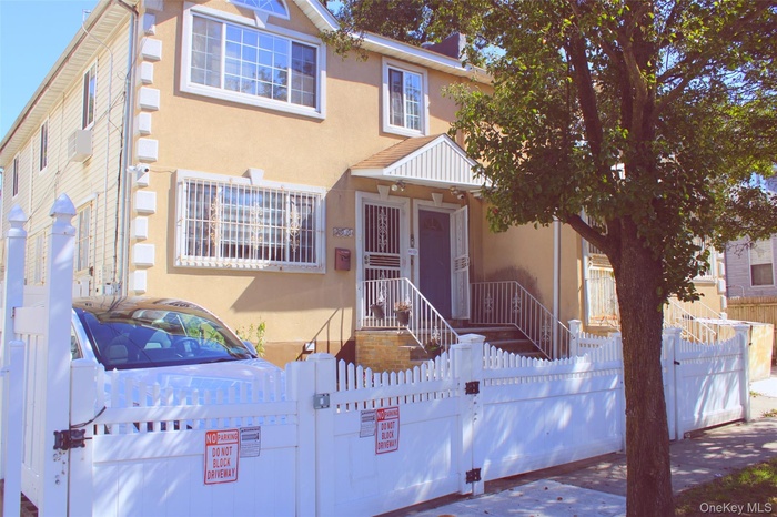 Traditional-style house featuring a gate, stucco siding, and a fenced front yard