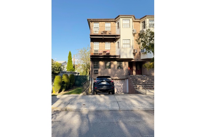 View of front facade with brick siding, an attached garage, and driveway