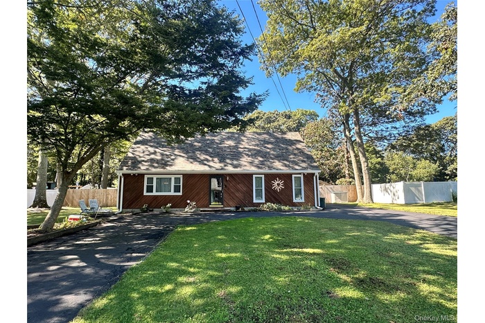 View of front of home with driveway and a shingled roof