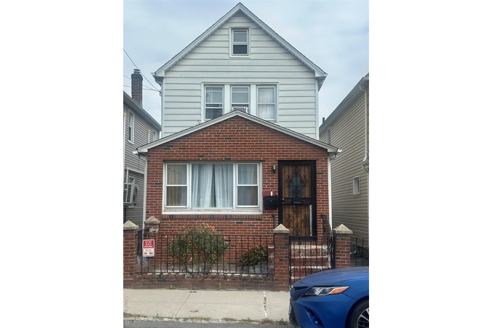 View of front of house featuring brick siding and a fenced front yard
