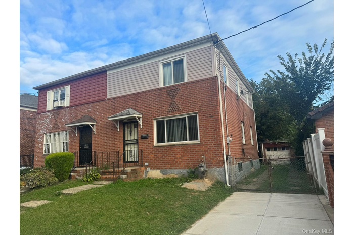 Traditional-style home featuring brick siding and a gate